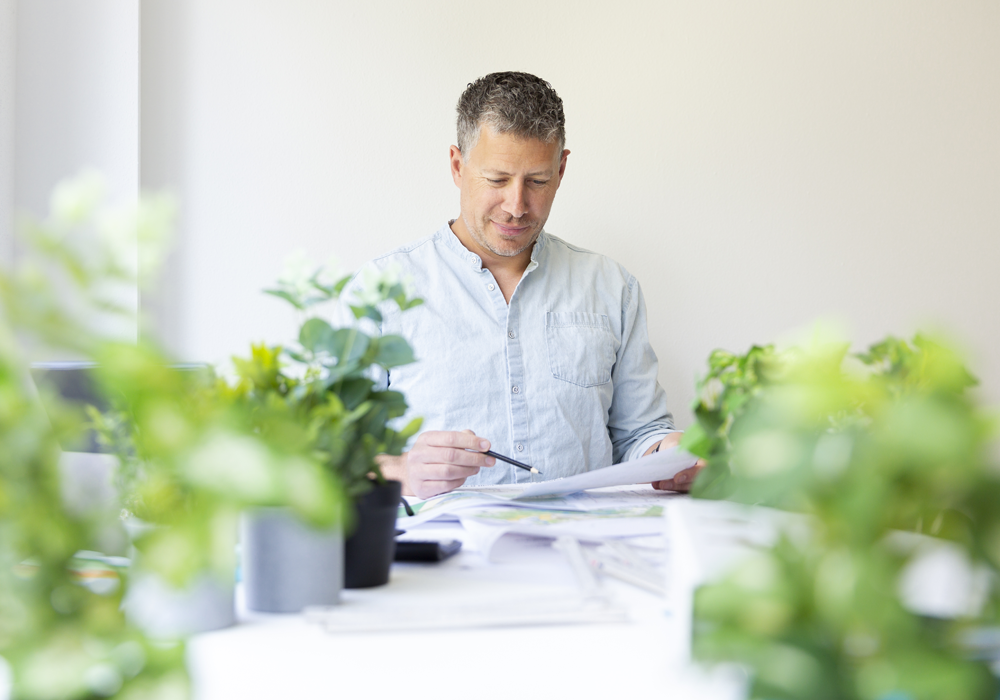 Mannelijke ondernemer bekijkt zijn administratie Mannelijke ondernemer bekijkt zijn administratie